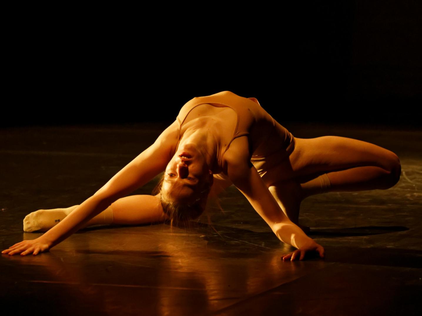 Contemporary dancer lying on a stage with her arms above her head