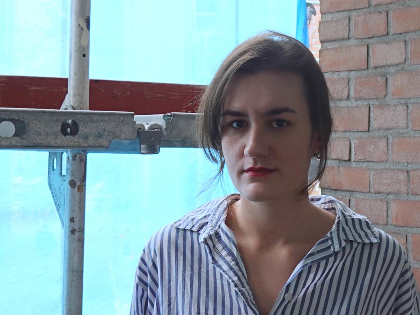 Portrait photo of woman standing in front of window