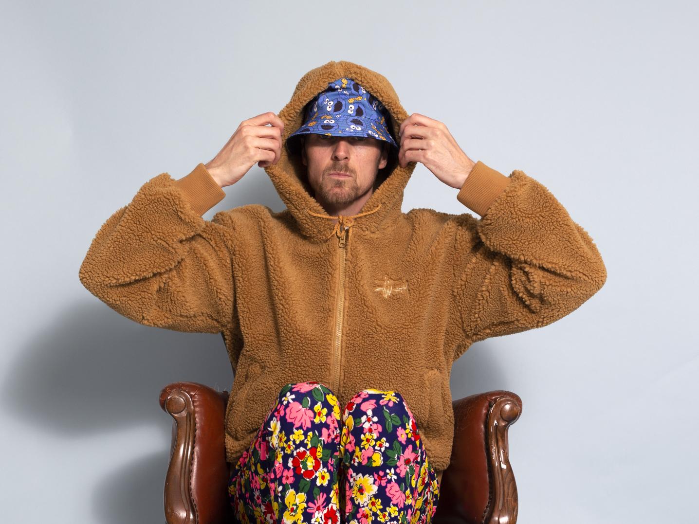 Man wearing colourful clothes sitting on a chair