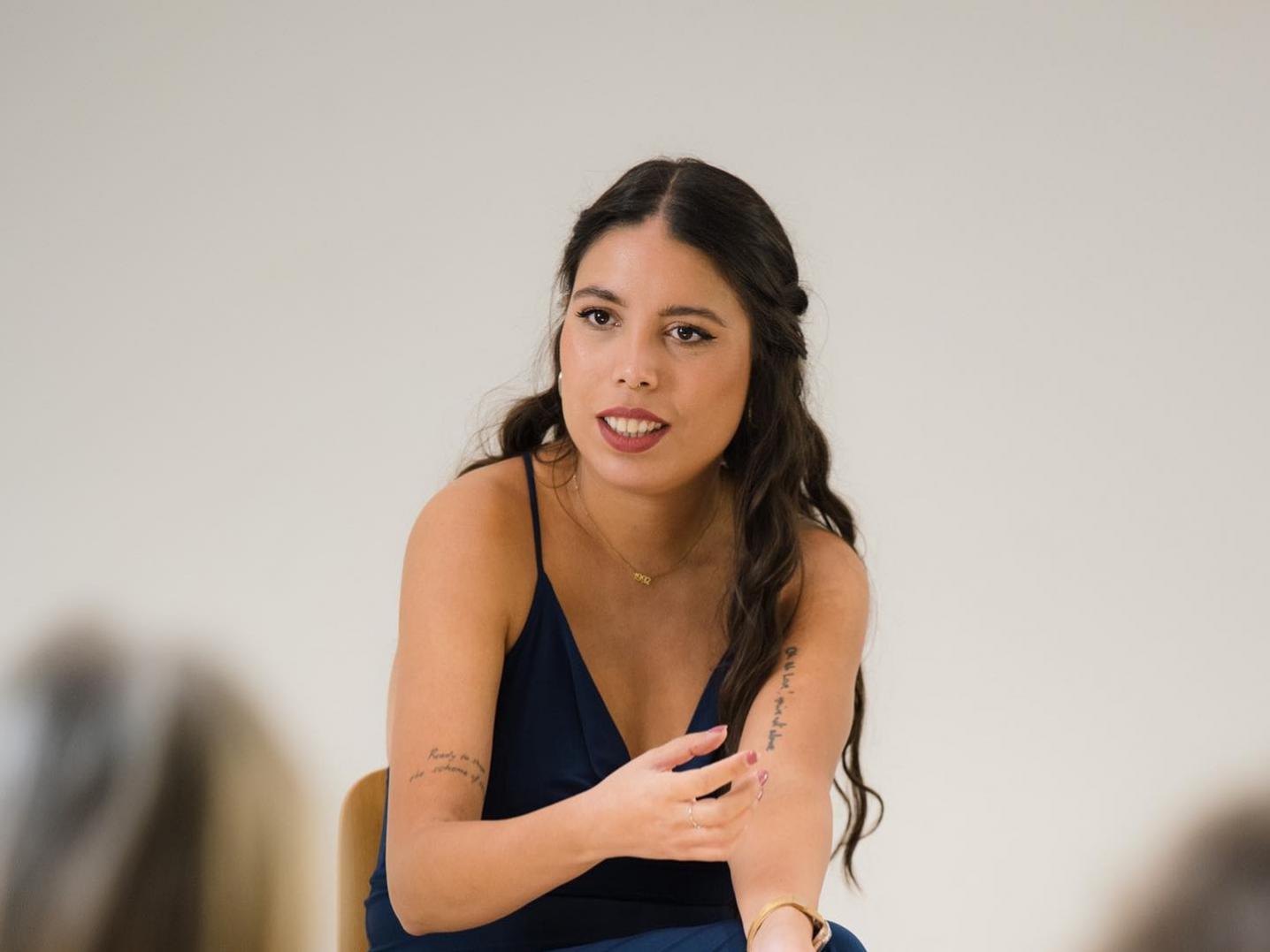 Amber-Helena Reisig sitting on a wooden chair during one of her performances