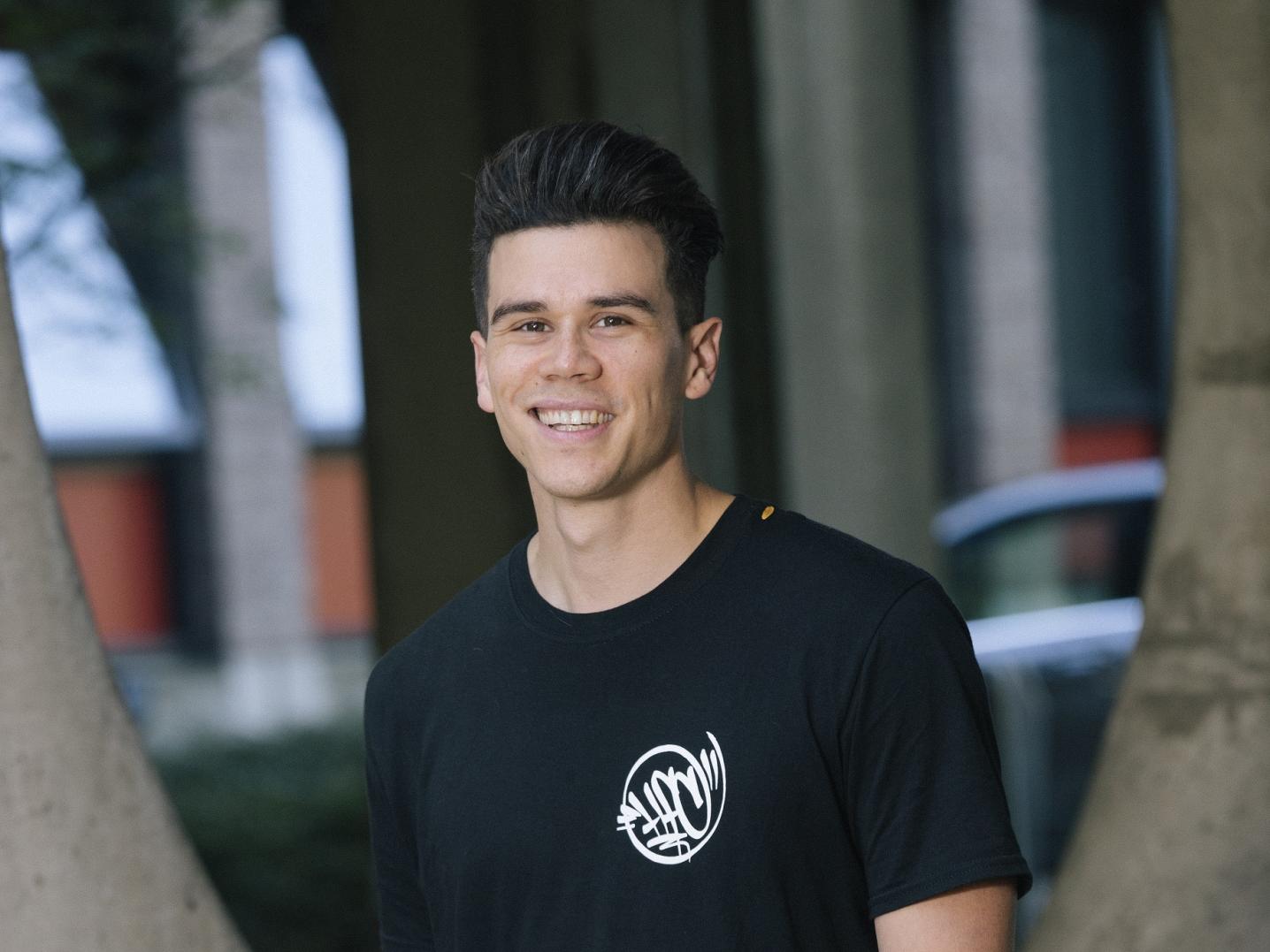 Portrait of Jop Vermeersch standing in front of an industrial background