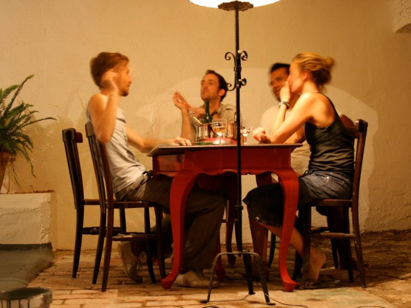 Four people sitting at a table having dinner at night