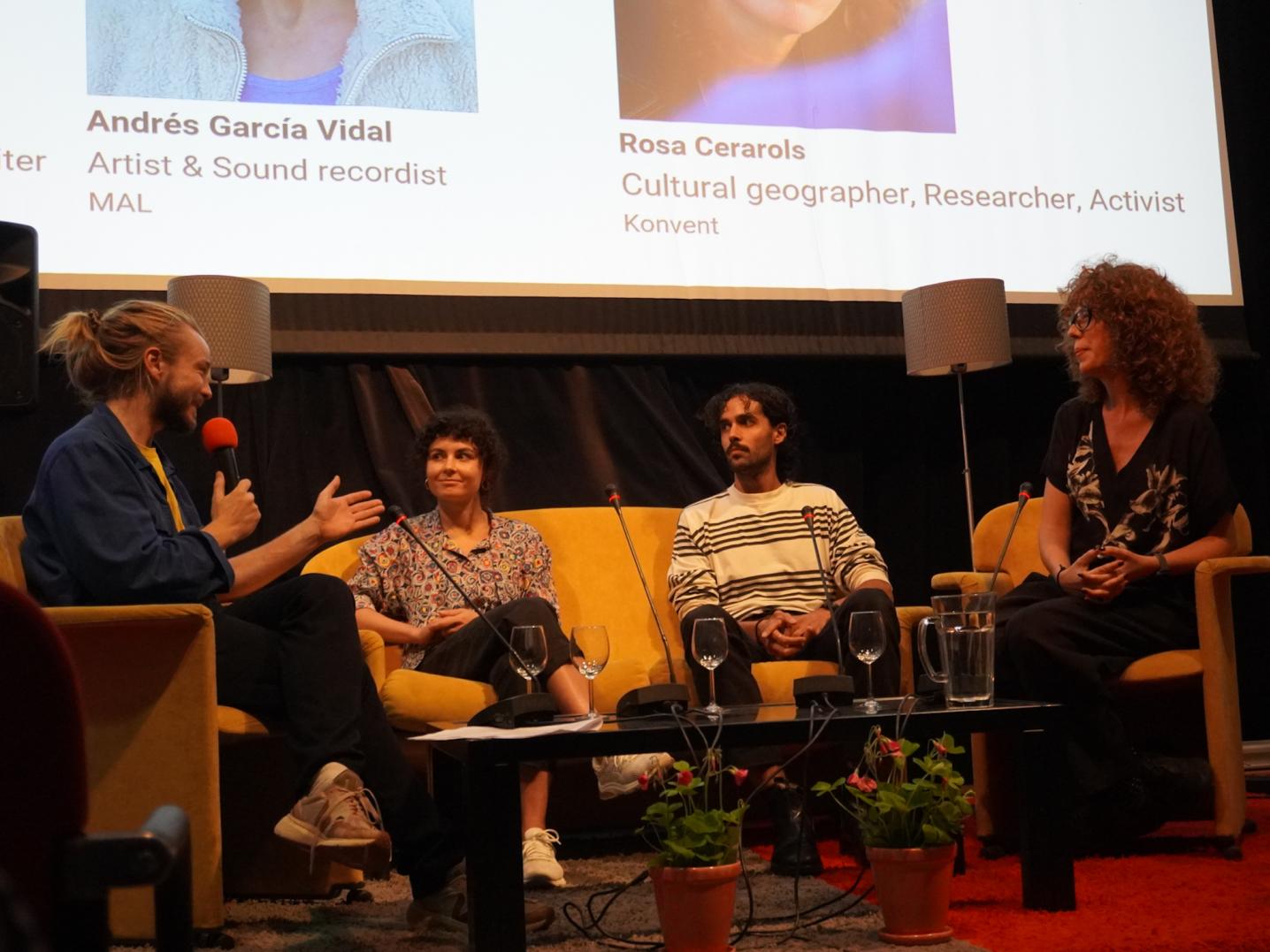 speakers and moderator sitting on a stage