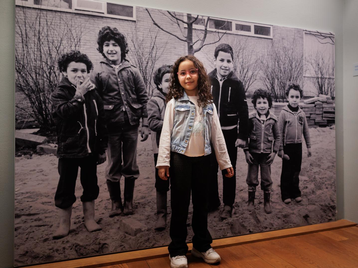 Meisje staat voor een zwart-wit foto in een museum