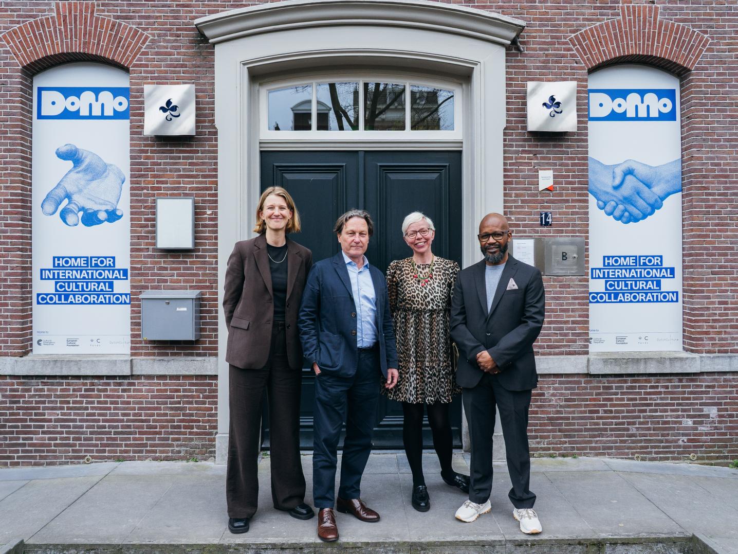 Directors of Cultural Emergency Response, European Cultural Foundation, DutchCulture, and Prince Claus Fund stands in front of the main door of the Domo complex.