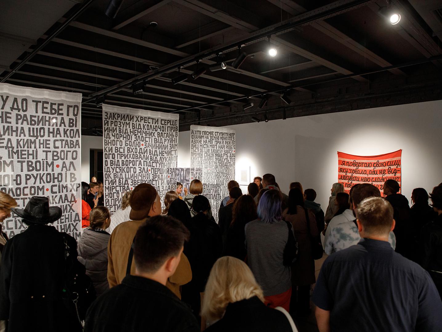 A group of people visiting an exhibition in an arts space