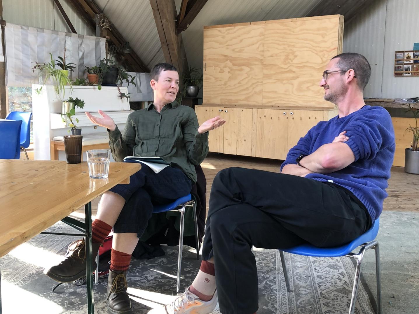 two people chatting and sitting on chairs in nice house