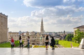 Some people are overlooking the city of Brussels, Belgium from a square