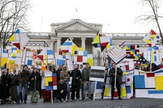 a group of people demonstrating with colourful flags and signs