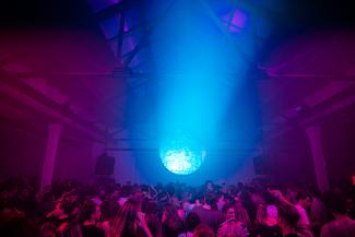 Blue light shining onto dance floor with people dancing