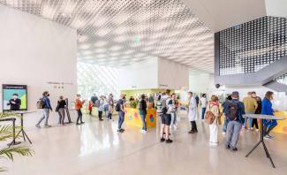 A group of people standing in a big modern hall
