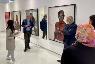 A group of people standing in the Mohammed VI Museum of Modern and Contemporary Art in Rabat, Morocco, in front of large photographic works