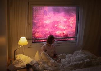 Woman sitting on bed in front of window with protest scene