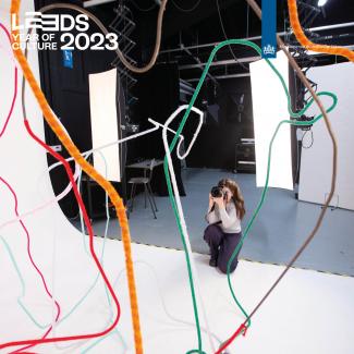 A woman is taking photographs in a photography studio