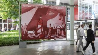 people walking in front of a big Salone del Mobile banner 