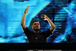 DJ Martin Garrix performing in front of a bright blue screen