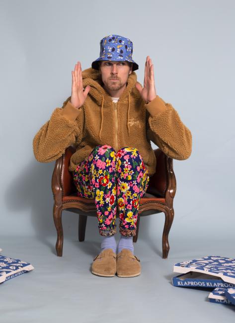 Man sitting on a chair wearing colourful clothes