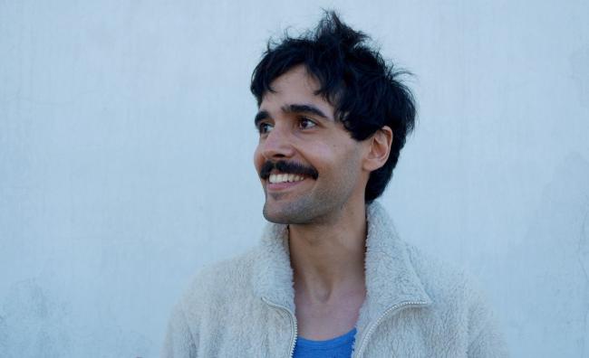 Spanish artist Andrés García Vidal posing in front of a white wall 