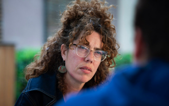 Rosa Cerarols in conversation with a person in a blue hoodie