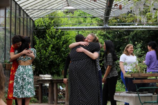 People hugging each other in a greenhouse