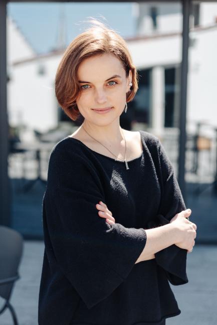 A woman posing with a building in the background