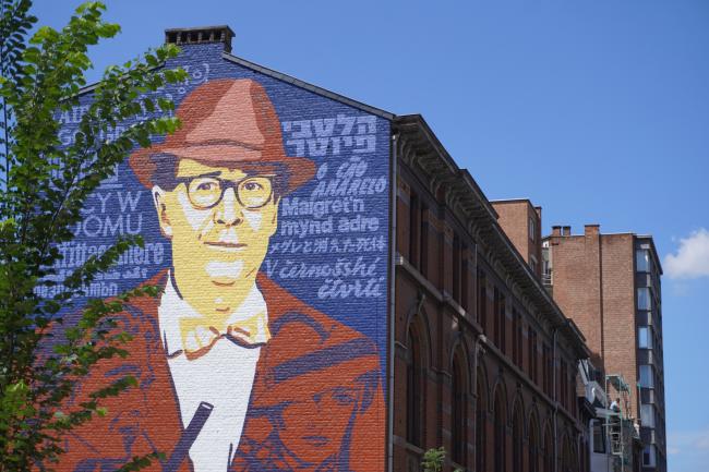 House front with a huge art mural depicting a famous Belgian writer.