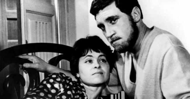 A black and white still from the film Brief Encounters. Kira Muratova and Vladimir Vysotsky sitting close together indoors, the man leaning in as they look ahead pensively