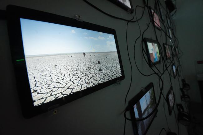 Exhibiton view with a screen showing a desert.