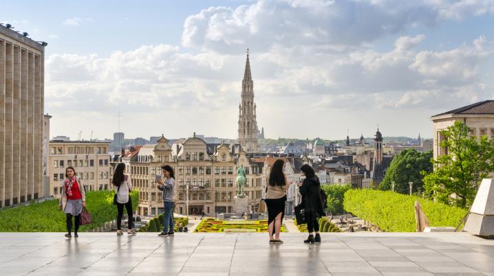 Some people are overlooking the city of Brussels, Belgium from a square