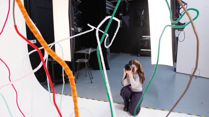 A woman is taking photographs in a photography studio