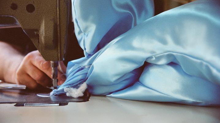 A textile artist sewing a quilt with machinery