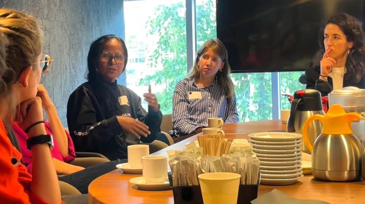 Four women at a table talking and listening