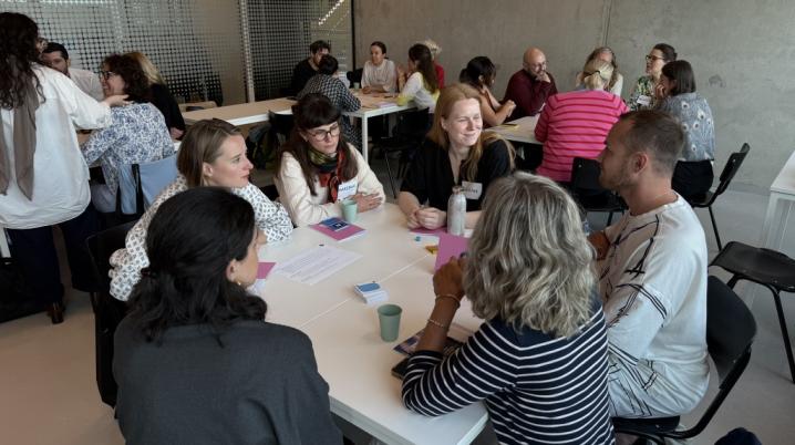Group of six people at a table talking with each other