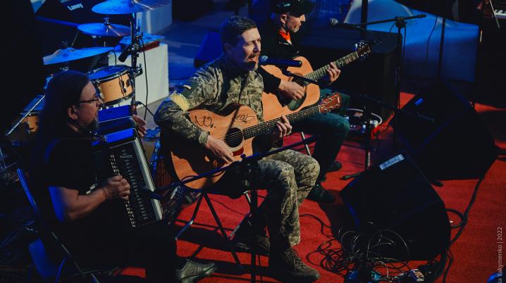 Three men performing music in a closed stage in Ukraine