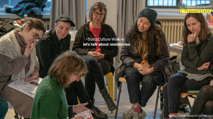 Group of people on chairs looking at a card held by someone