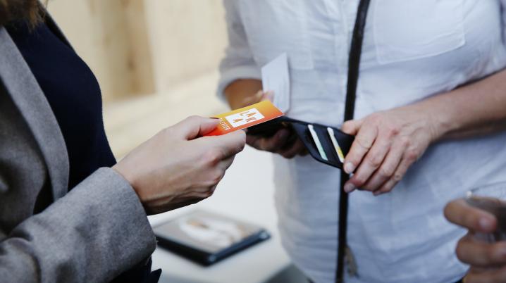 Two people exchange business cards