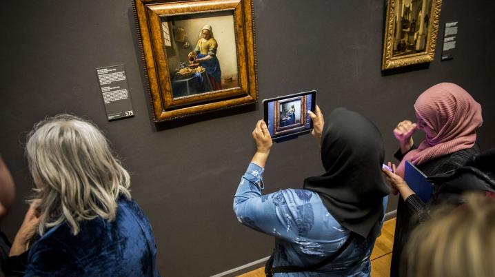Visitors admire the painting of the Milkmaid by Vermeer at the Rijksmuseum